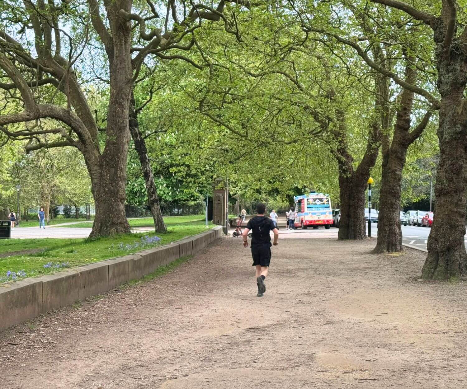 A jogger running along the wide street that circles Sefton Park in Aigburth., popular with young professionals who run, walk and cycle around the park