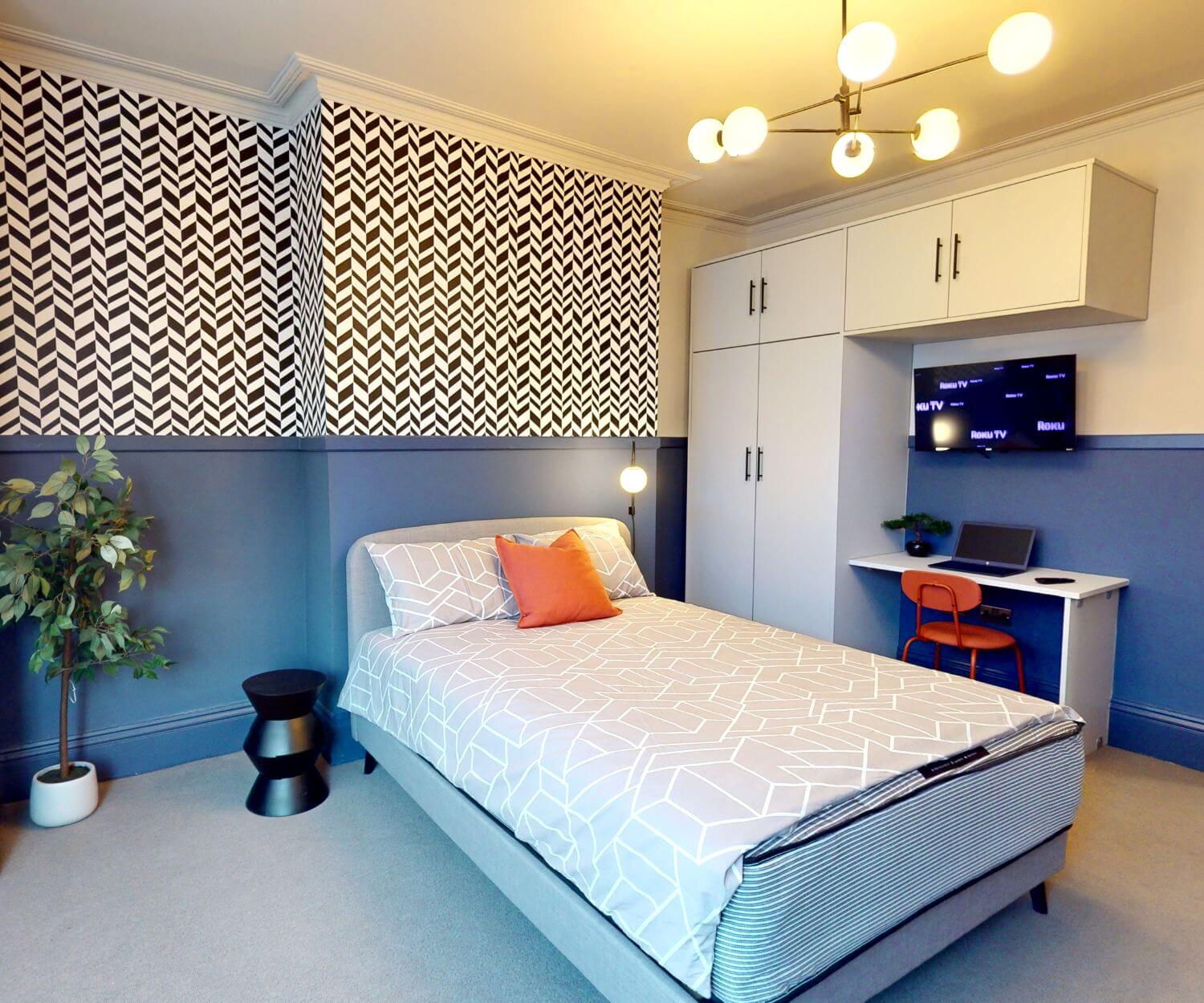 Spacious double bedroom with a double bed, desk & chair, wardrobe and smart TV in a professional house share