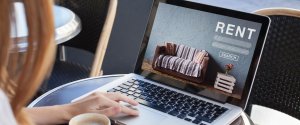A graduate searching for information on renting in Liverpool using a laptop