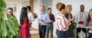 Diverse group of professionals networking at modern Liverpool office event with drinks